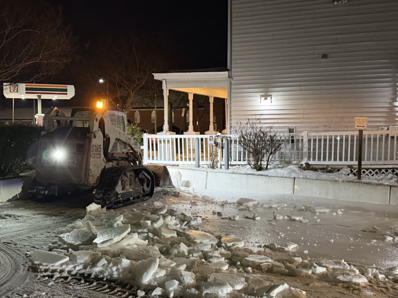 Compact track loader clearing snow from commercial parking lot in Stafford VA