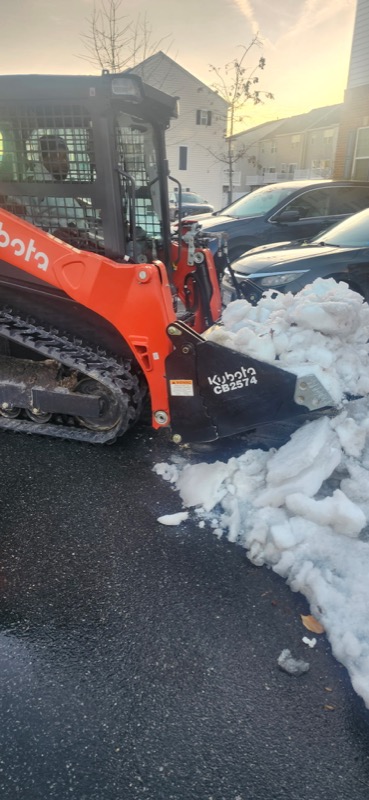 Kubota compact track loader with bucket spreading material on job site