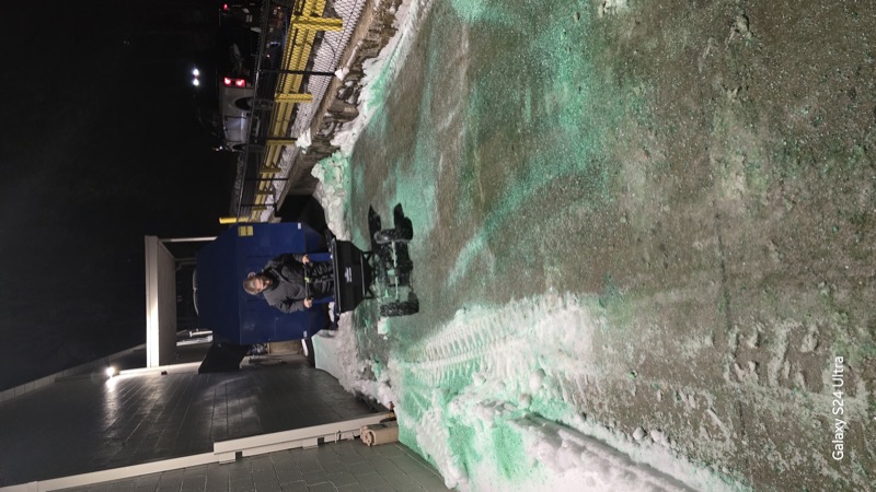 Skid steer operator removing debris at night during emergency cleanup